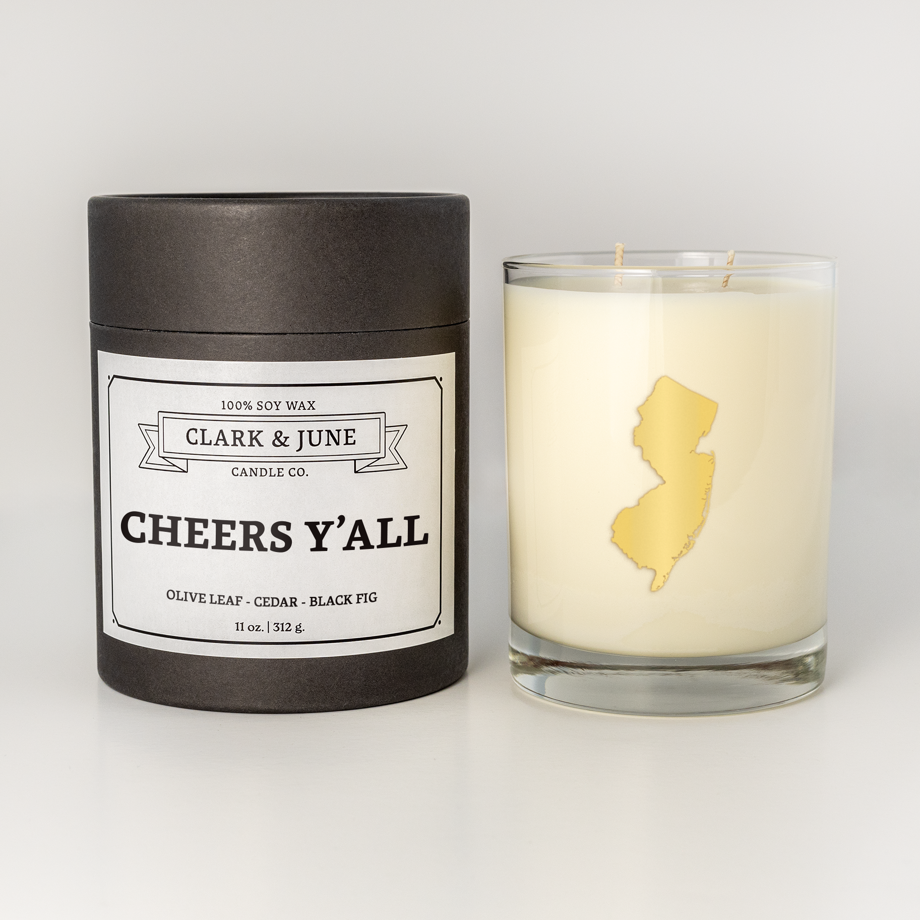 Double wicked soy candle in a 13.5 oz tumbler with the state of  New Jersey printed in 22k gold foil on the face. Black cylinder packaging with Cheers Y'All on the label. SEO Text – Drinking glass, soy wax candle, Christmas Candle, hand poured, small batch, scented candle, Woman Owned, local candle, Housewarming present, gives back, charity, community candle, becomes a cocktail glass, closing gift.