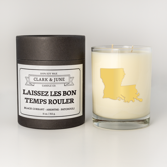 Double wicked soy candle in a 13.5 oz tumbler with the state of  Louisiana printed in 22k gold foil on the face. Black cylinder packaging with Laissez les bon temps rouler on the label. SEO Text – Drinking glass, soy wax candle, Christmas Candle, hand poured, small batch, scented candle, Woman Owned, local candle, Housewarming present, gives back, charity, community candle, becomes a cocktail glass, closing gift.