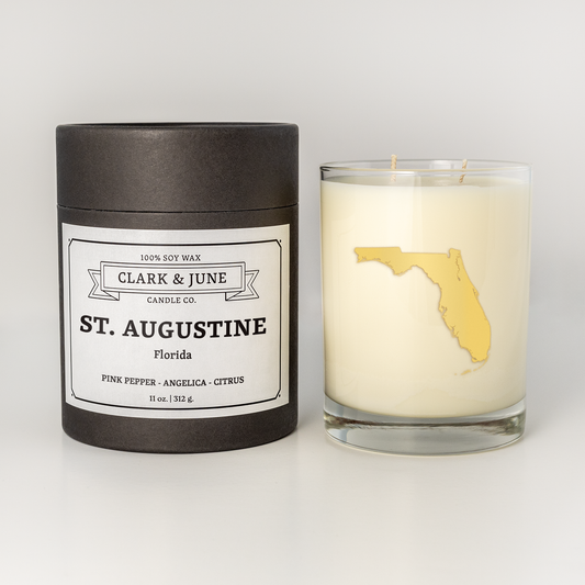 Double wicked soy candle in a 13.5 oz tumbler with the state of  Florida printed in 22k gold foil on the face. Black cylinder packaging with St. Augustine  on the label. SEO Text – Drinking glass, soy wax candle, Christmas Candle, hand poured, small batch, scented candle, Woman Owned, local candle, Housewarming present, gives back, charity, community candle, becomes a cocktail glass, closing gift.