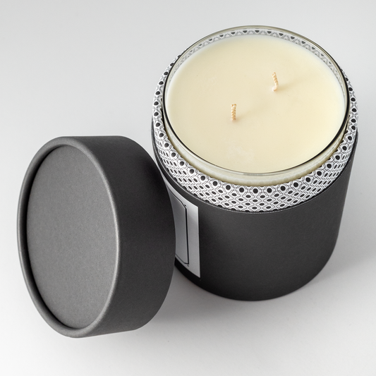 Double wicked soy wax candle inside of black packaging