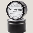 Load image into Gallery viewer, Single wicked 8oz candle in a black finish with Gatlinburg on the label. SEO Text –soy wax candle, Tennessee candle, hand poured, small batch, scented candle, Woman Owned, local candle, Housewarming present, gives back, charity, community candle, closing gift.
