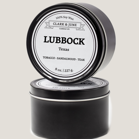 Single wicked 8oz candle in a black finish with Lubbock  on the label. SEO Text –soy wax candle, Texas candle, hand poured, small batch, scented candle, Woman Owned, local candle, Housewarming present, gives back, charity, community candle, closing gift.