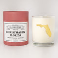 Load image into Gallery viewer, Double wicked soy candle in a 13.5 oz tumbler with the state of  Florida printed in 22k gold foil on the face. Red cylinder packaging with Christmas in Florida on the label. SEO Text – Drinking glass, soy wax candle, Christmas Candle, hand poured, small batch, scented candle, Woman Owned, local candle, Housewarming present, gives back, charity, community candle, becomes a cocktail glass, closing gift.
