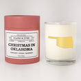Load image into Gallery viewer, Double wicked soy candle in a 13.5 oz tumbler with the state of  Oklahoma printed in 22k gold foil on the face. Red cylinder packaging with Christmas in Oklahoma on the label. SEO Text – Drinking glass, soy wax candle, Christmas Candle, hand poured, small batch, scented candle, Woman Owned, local candle, Housewarming present, gives back, charity, community candle, becomes a cocktail glass, closing gift.
