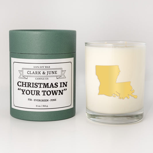 Double wicked soy candle in a 13.5 oz tumbler with the state of   Louisiana printed in 22k gold foil on the face. Green cylinder packaging with Christmas in "Your Town" on the label. SEO Text – Drinking glass, soy wax candle, Christmas Candle, hand poured, small batch, scented candle, Woman Owned, local candle, Housewarming present, gives back, charity, community candle, becomes a cocktail glass, closing gift.