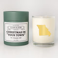 Load image into Gallery viewer, Double wicked soy candle in a 13.5 oz tumbler with the state of   Missouri printed in 22k gold foil on the face. Green cylinder packaging with Christmas in "Your Town" on the label. SEO Text – Drinking glass, soy wax candle, Christmas Candle, hand poured, small batch, scented candle, Woman Owned, local candle, Housewarming present, gives back, charity, community candle, becomes a cocktail glass, closing gift.