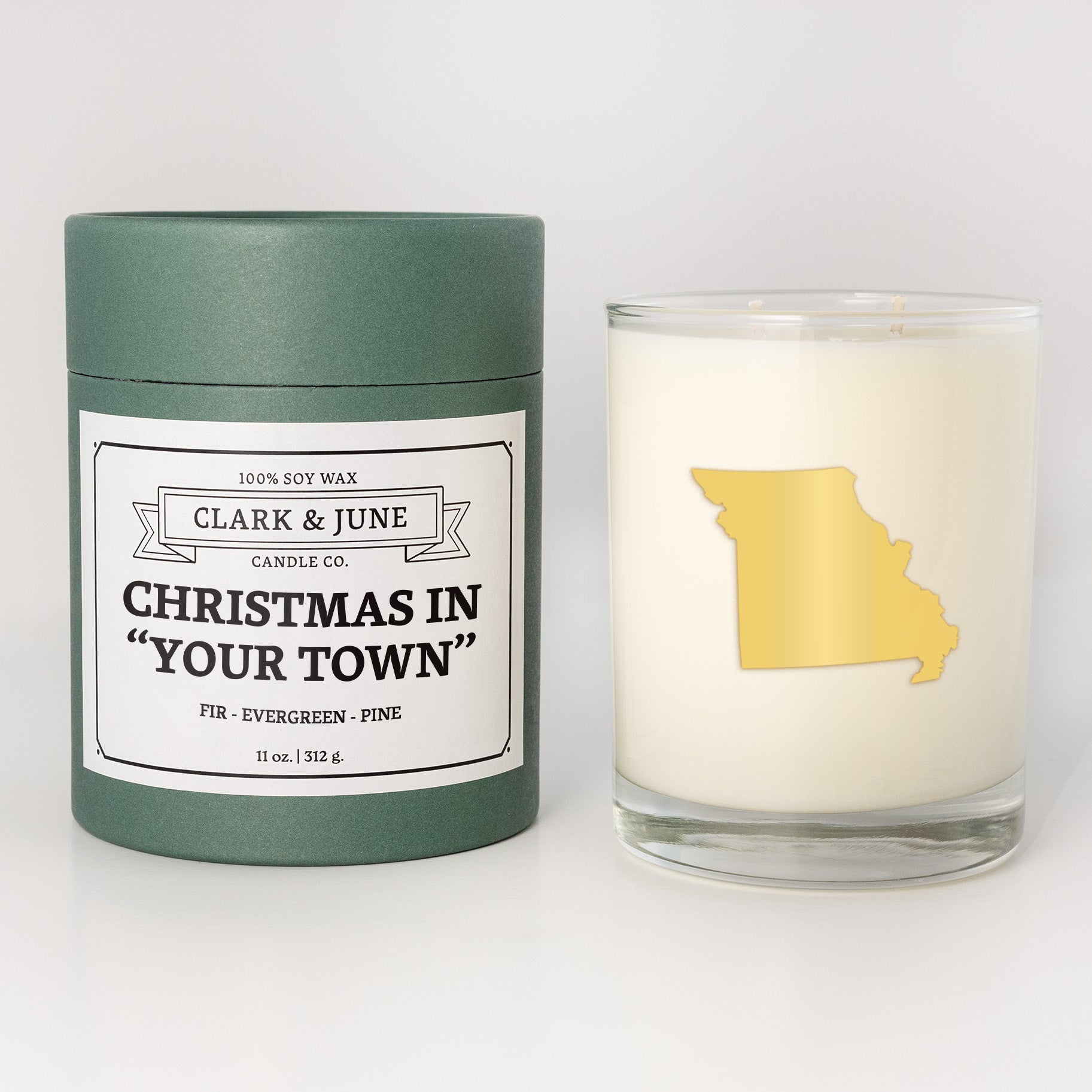 Double wicked soy candle in a 13.5 oz tumbler with the state of   Missouri printed in 22k gold foil on the face. Green cylinder packaging with Christmas in "Your Town" on the label. SEO Text – Drinking glass, soy wax candle, Christmas Candle, hand poured, small batch, scented candle, Woman Owned, local candle, Housewarming present, gives back, charity, community candle, becomes a cocktail glass, closing gift.