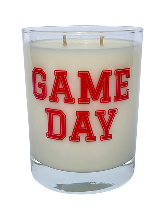 Double wicked soy candle in a 13.5 oz tumbler with the Game Day printed on the face of the vessel in Red. SEO Text – Drinking glass, soy wax candle, Football, Tailgate, hand poured, small batch, scented candle, Woman Owned, local candle, Housewarming present, gives back, charity, community candle, becomes a cocktail glass, closing gift.