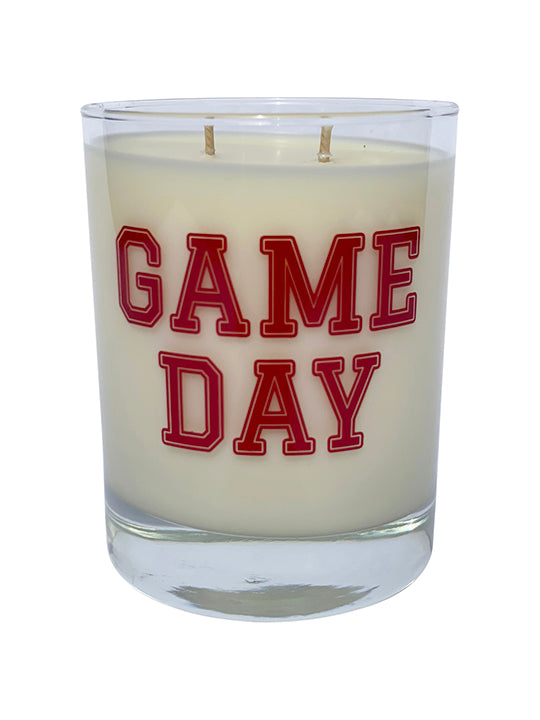 Double wicked soy candle in a 13.5 oz tumbler with the Game Day printed on the face of the vessel in Red. SEO Text – Drinking glass, soy wax candle, Football, Tailgate, hand poured, small batch, scented candle, Woman Owned, local candle, Housewarming present, gives back, charity, community candle, becomes a cocktail glass, closing gift.