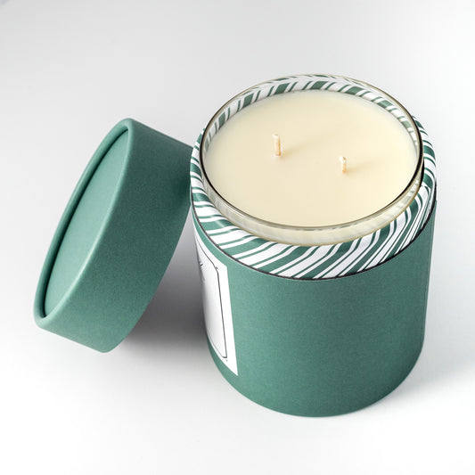 Double wicked soy wax candle inside of Green holiday packaging