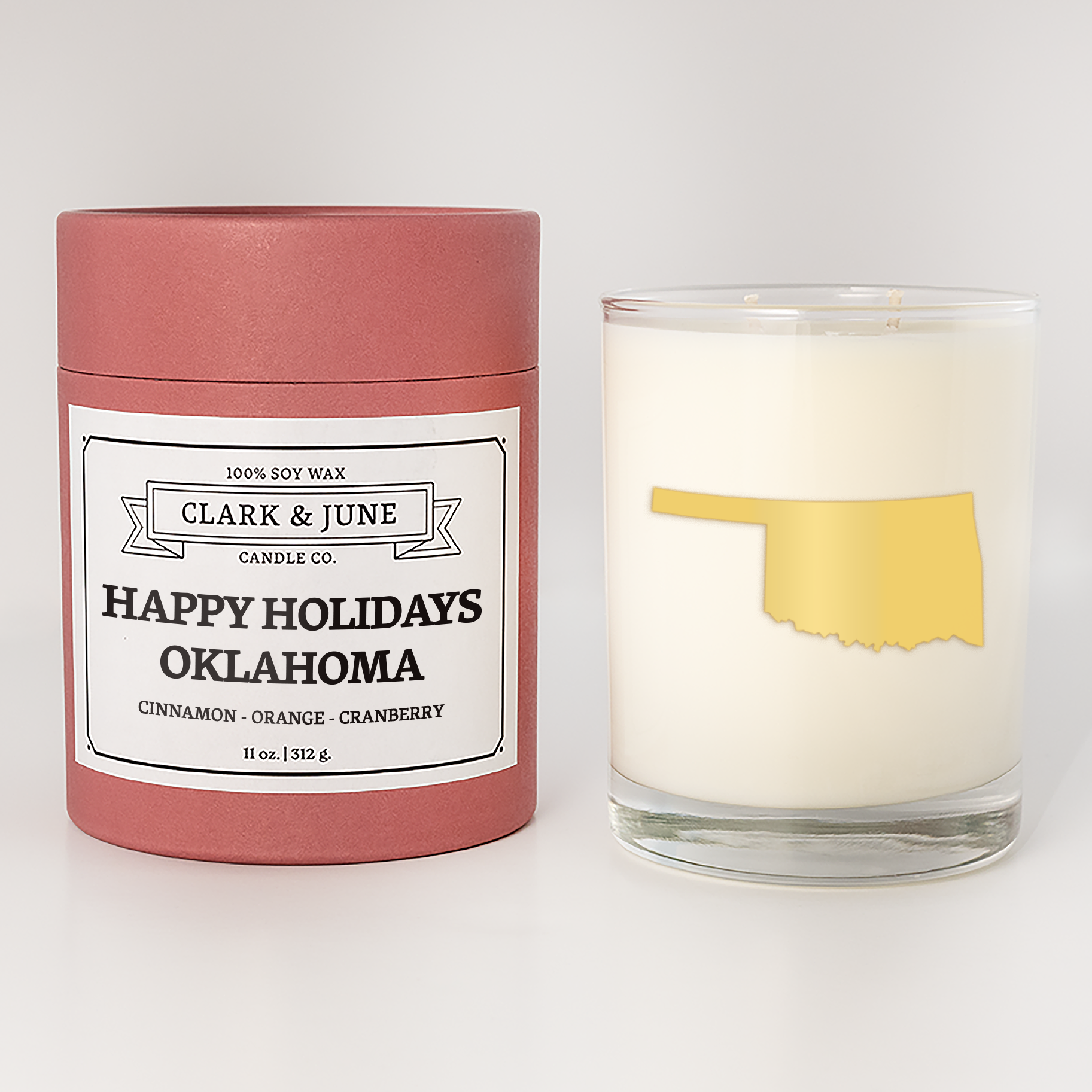 Double wicked soy candle in a 13.5 oz tumbler with the state of  Oklahoma printed in 22k gold foil on the face. Red cylinder packaging with Happy Holidays Oklahoma on the label. SEO Text – Drinking glass, soy wax candle, Christmas Candle, hand poured, small batch, scented candle, Woman Owned, local candle, Housewarming present, gives back, charity, community candle, becomes a cocktail glass, closing gift.