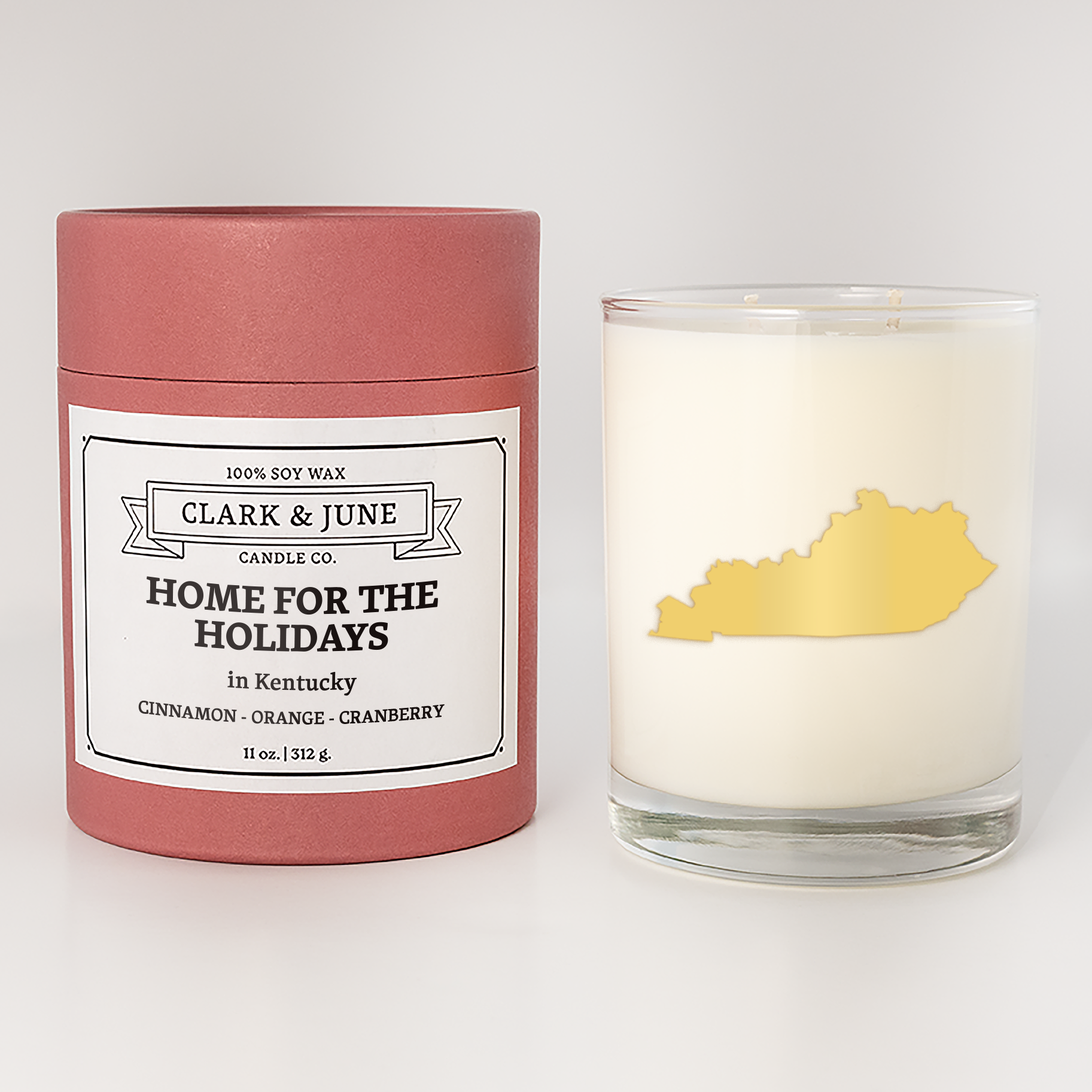 Double wicked soy candle in a 13.5 oz tumbler with the state of  Kentucky printed in 22k gold foil on the face. Red cylinder packaging with Home for the Holidays  Kentucky on the label. SEO Text – Drinking glass, soy wax candle, Christmas Candle, hand poured, small batch, scented candle, Woman Owned, local candle, Housewarming present, gives back, charity, community candle, becomes a cocktail glass, closing gift.