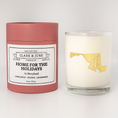 Load image into Gallery viewer, Double wicked soy candle in a 13.5 oz tumbler with the state of  Maryland printed in 22k gold foil on the face. Red cylinder packaging with Home for the Holidays  Maryland on the label. SEO Text – Drinking glass, soy wax candle, Christmas Candle, hand poured, small batch, scented candle, Woman Owned, local candle, Housewarming present, gives back, charity, community candle, becomes a cocktail glass, closing gift.