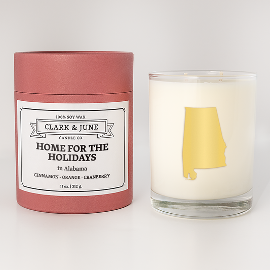 Double wicked soy candle in a 13.5 oz tumbler with the state of  Alabama printed in 22k gold foil on the face. Red cylinder packaging with Home for the Holidays  Alabama on the label. SEO Text – Drinking glass, soy wax candle, Christmas Candle, hand poured, small batch, scented candle, Woman Owned, local candle, Housewarming present, gives back, charity, community candle, becomes a cocktail glass, closing gift.