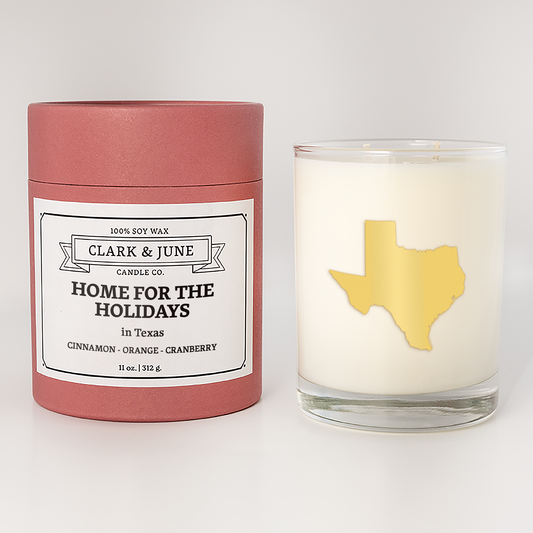 Double wicked soy candle in a 13.5 oz tumbler with the state of  Texas printed in 22k gold foil on the face. Red cylinder packaging with Home for the Holidays on the label. SEO Text – Drinking glass, soy wax candle, Christmas Candle, hand poured, small batch, scented candle, Woman Owned, local candle, Housewarming present, gives back, charity, community candle, becomes a cocktail glass, closing gift.