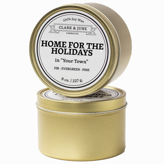 Single wicked Fir - Evergreen - Pine scented 8oz candle in gold finish with Home for the Holidays in "Your Town" on the label. SEO Text –soy wax candle, Christmas candle, Holiday candle hand poured, small batch, scented candle, Woman Owned, local candle, Housewarming present, gives back, charity, community candle, Soy wax candle Christmas gift.