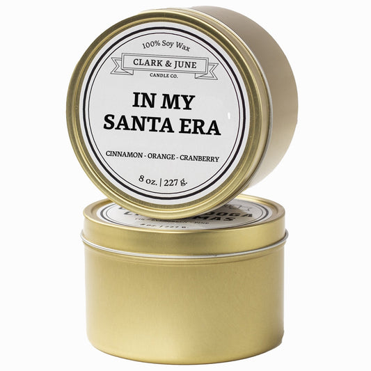 Single wicked Cinnamon - Orange - Cranberry  scented 8oz candle in gold finish with In My Santa Era on the label. SEO Text –soy wax candle, Christmas candle, Holiday candle hand poured, small batch, scented candle, Woman Owned, local candle, Housewarming present, gives back, charity, community candle, Soy wax candle Christmas gift.