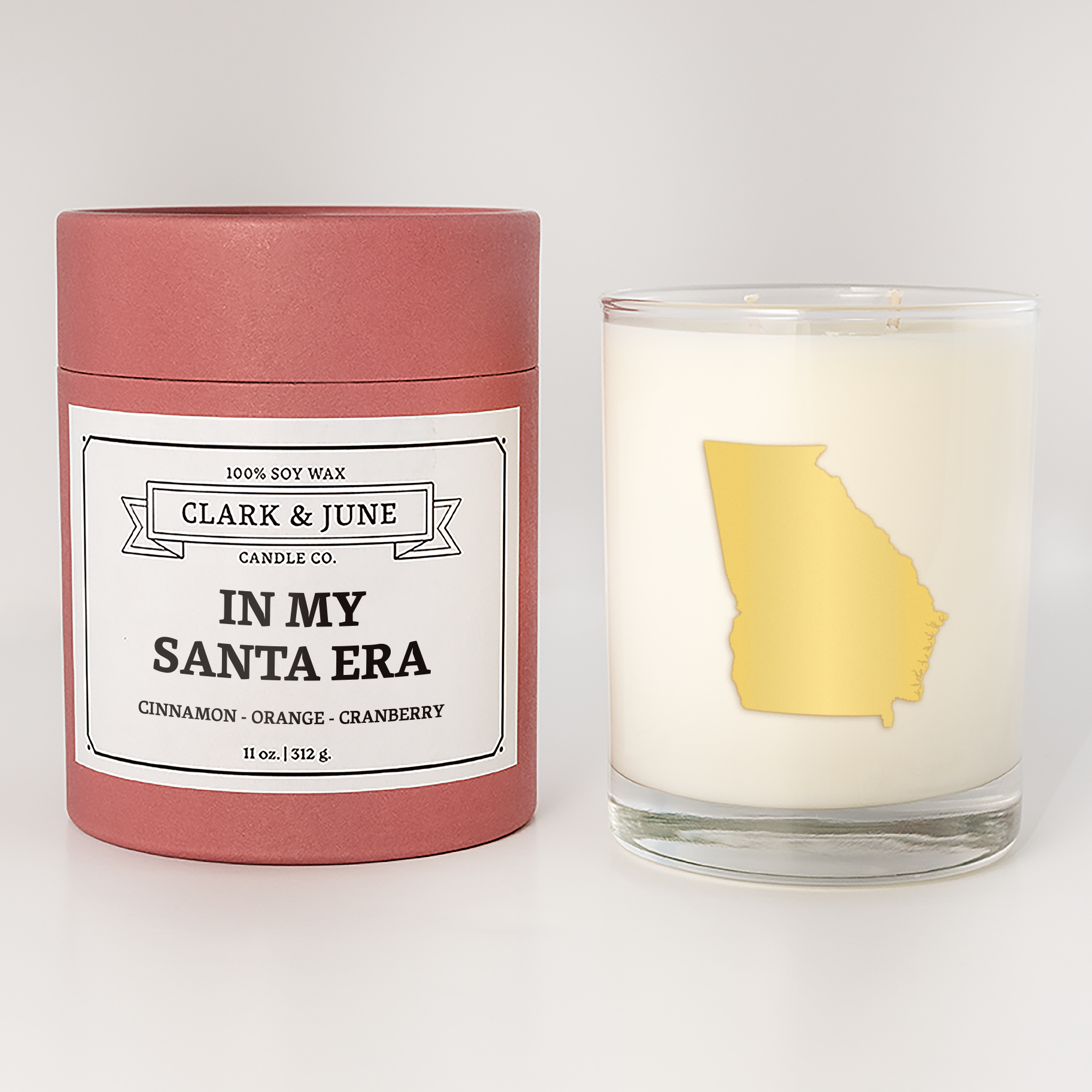Double wicked soy candle in a 13.5 oz tumbler with the state of  Georgia printed in 22k gold foil on the face. Red cylinder packaging with In My Santa Era on the label. SEO Text – Drinking glass, soy wax candle, Christmas Candle, hand poured, small batch, scented candle, Woman Owned, local candle, Housewarming present, gives back, charity, community candle, becomes a cocktail glass, closing gift.