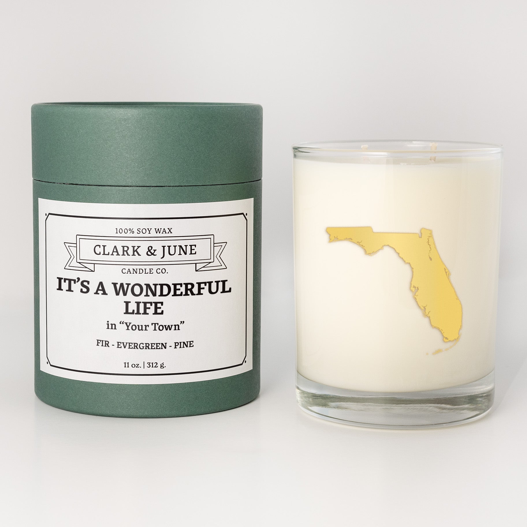 Double wicked soy candle in a 13.5 oz tumbler with the state of   Florida printed in 22k gold foil on the face. Green cylinder packaging with It's a Wonderful Life in "Your Town" on the label. SEO Text – Drinking glass, soy wax candle, Christmas Candle, hand poured, small batch, scented candle, Woman Owned, local candle, Housewarming present, gives back, charity, community candle, becomes a cocktail glass, closing gift.