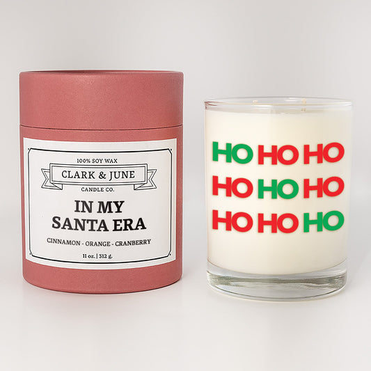 Double wicked soy candle in a 13.5 oz tumbler with HO HO HO printed on the face. Red cylinder packaging withIn my Santa Eraon the label. SEO Text – Drinking glass, soy wax candle, Christmas Candle, hand poured, small batch, scented candle, Woman Owned, local candle, Housewarming present, gives back, charity, community candle, becomes a cocktail glass, closing gift.