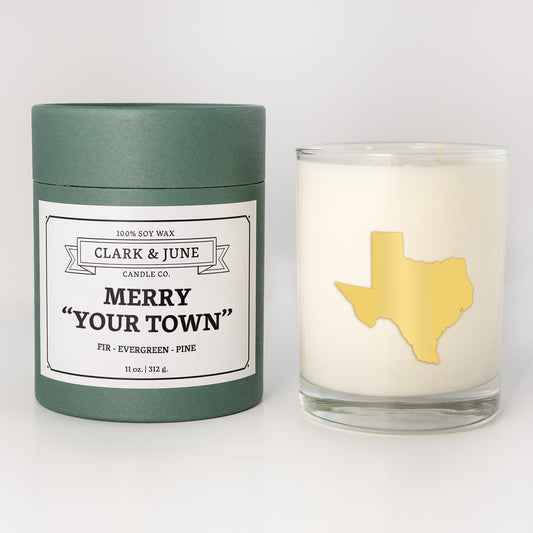 Double wicked soy candle in a 13.5 oz tumbler with the state of Texasprinted in 22k gold foil on the face. Green cylinder packaging with Merry "Your Town" on the label. SEO Text – Drinking glass, soy wax candle, Christmas Candle, hand poured, small batch, scented candle, Woman Owned, local candle, Housewarming present, gives back, charity, community candle, becomes a cocktail glass, closing gift.