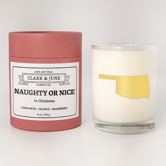 Double wicked soy candle in a 13.5 oz tumbler with the state of  Oklahoma printed in 22k gold foil on the face. Red cylinder packaging with Naughty or Nice on the label. SEO Text – Drinking glass, soy wax candle, Christmas Candle, hand poured, small batch, scented candle, Woman Owned, local candle, Housewarming present, gives back, charity, community candle, becomes a cocktail glass, closing gift.