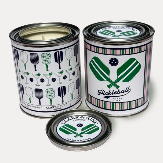14oz Pickleball design soy wax candle in a pint sized paint can made by Clark & June Candle Co. The candle is wrapped with a salmon and white label with pickleball paddles and martini glasses on the back and a crossed pickleball paddles with the phrase “pickleball social club” on the front. The scent is Olive Leaf – Cedar – Black Fig and was hand poured in small batches. 
Scented Candle, Paint Can Candle. Single Cotton Wick, Western, Pickleball core