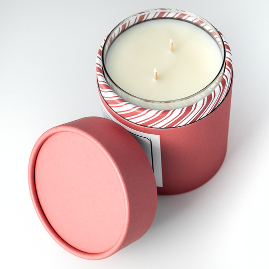 Double wicked soy wax candle inside of red holiday packaging