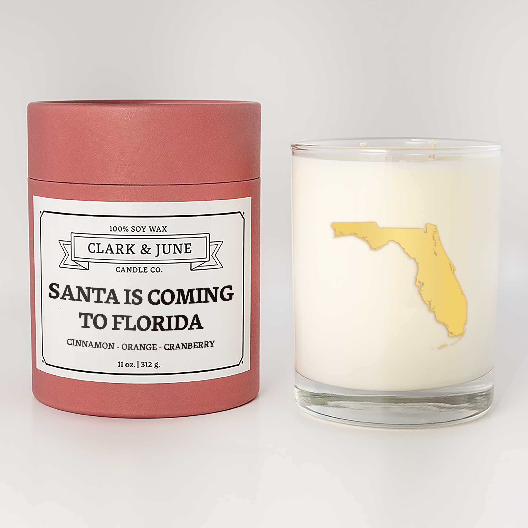 Double wicked soy candle in a 13.5 oz tumbler with the state of  Florida printed in 22k gold foil on the face. Red cylinder packaging with Santa is Coming to Florida on the label. SEO Text – Drinking glass, soy wax candle, Christmas Candle, hand poured, small batch, scented candle, Woman Owned, local candle, Housewarming present, gives back, charity, community candle, becomes a cocktail glass, closing gift.
