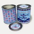 Load image into Gallery viewer, 14oz Sardine design soy wax candle in a pint sized paint can made by Clark & June Candle Co. The candle is wrapped with a blue and red label showing a repeating pattern of blue and red sardines on the back and a recreation of a can of sardines in olive oil on the front. The scent is Seasalt – Orchid - Kelp and was hand poured in small batches. 
Sardine Candle, Scented Candle, Paint Can Candle. Single Cotton Wick, Fish Core