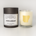 Load image into Gallery viewer, Double wicked soy candle in a 13.5 oz tumbler with the state of Arkansas printed in 22k gold foil on the face. Black cylinder packaging with “Arkansas” on the label. SEO Text – Drinking glass, soy wax candle, Alabama candle, hand poured, small batch, scented candle, Woman Owned, local candle, Housewarming present, gives back, charity, community candle, becomes a cocktail glass, closing gift. 
