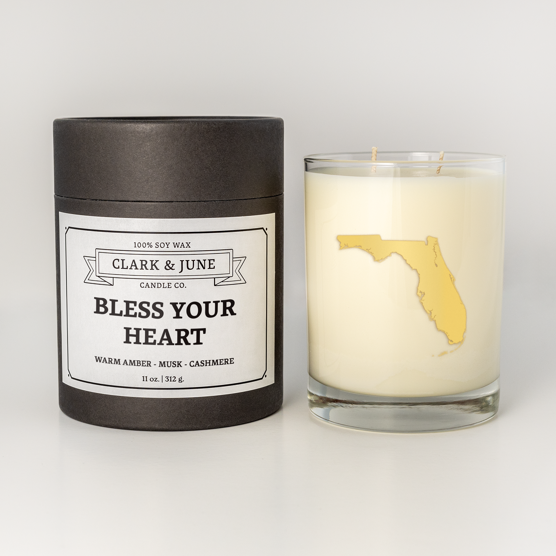 Double wicked soy candle in a 13.5 oz tumbler with the state of  Florida printed in 22k gold foil on the face. Black cylinder packaging with “Bless Your Heart” on the label. 