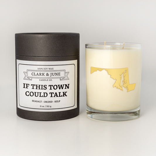 Double wicked soy candle in a 13.5 oz tumbler with the state of Maryland printed in 22k gold foil on the face. Black cylinder packaging with “If This Town Could Talk” on the label. SEO Text – Drinking glass, soy wax candle, Maryland candle, hand poured, small batch, scented candle, Woman Owned, local candle, Housewarming present, gives back, charity, community candle, becomes a cocktail glass, closing gift.