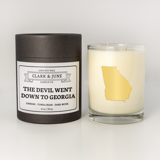 Double wicked soy candle in a 13.5 oz tumbler with the state of Georgia printed in 22k gold foil on the face. Black cylinder packaging with “The Devil Went Down to Georgia” on the label. SEO Text – Drinking glass, soy wax candle, Alabama candle, hand poured, small batch, scented candle, Woman Owned, local candle, Housewarming present, gives back, charity, community candle, becomes a cocktail glass, closing gift. 