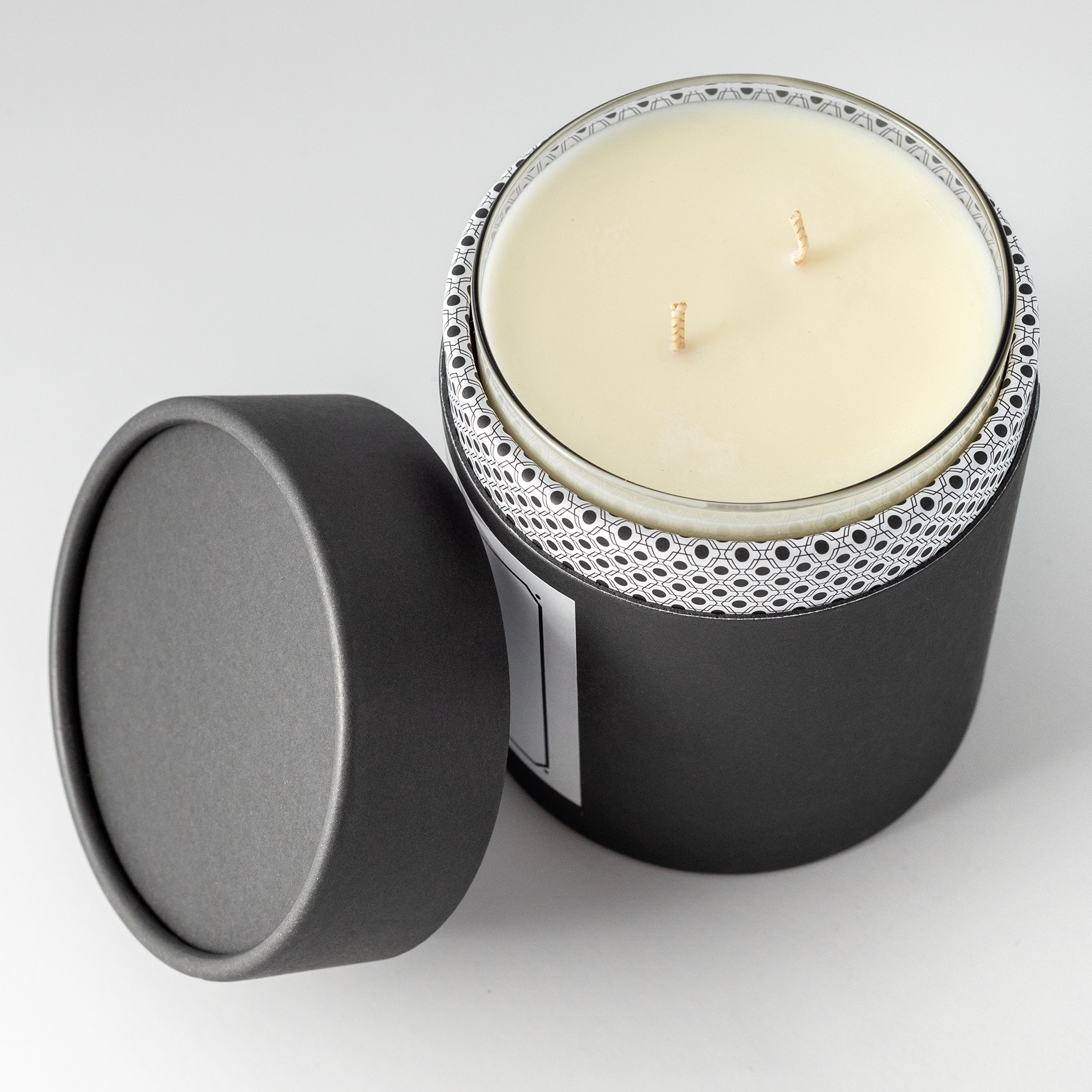 Double wicked soy wax candle inside of black packaging 