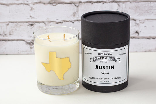 Double wicked soy candle in a 13.5 oz tumbler with the state of Texas printed in 22k gold foil on the face. Black cylinder packaging with “Austin Texas” on the label. SEO Text – Drinking glass, soy wax candle, Alabama candle, hand poured, small batch, scented candle, Woman Owned, local candle, Housewarming present, gives back, charity, community candle, becomes a cocktail glass, closing gift. 