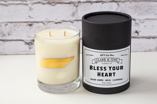 Double wicked soy candle in a 13.5 oz tumbler with the state of Tennessee printed in 22k gold foil on the face. Black cylinder packaging with “Bless Your Heart” on the label. SEO Text – Drinking glass, soy wax candle, Tennessee candle, hand poured, small batch, scented candle, Woman Owned, local candle, Housewarming present, gives back, charity, community candle, becomes a cocktail glass, closing gift.