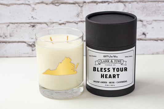 Double wicked soy candle in a 13.5 oz tumbler with the state of Virginia printed in 22k gold foil on the face. Black cylinder packaging with “Bless Your Heart” on the label. SEO Text – Drinking glass, soy wax candle, Virginia candle, hand poured, small batch, scented candle, Woman Owned, local candle, Housewarming present, gives back, charity, community candle, becomes a cocktail glass, closing gift.