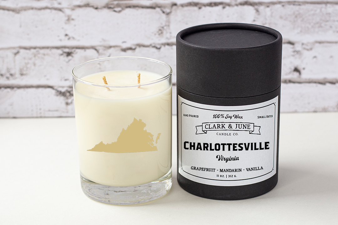 Double wicked soy candle in a 13.5 oz tumbler with the state of Virginia printed in 22k gold foil on the face. Black cylinder packaging with “Charlottesville, Virginia” on the label. SEO Text – Drinking glass, soy wax candle, Virginia candle, hand poured, small batch, scented candle, Woman Owned, local candle, Housewarming present, gives back, charity, community candle, becomes a cocktail glass, closing gift.