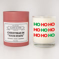 Load image into Gallery viewer, Double wicked soy candle in a 13.5 oz tumbler with Ho Ho Ho  printed on the face. Red cylinder packaging with Christmas in "Your State" on the label. SEO Text – Drinking glass, soy wax candle, Christmas Candle, hand poured, small batch, scented candle, Woman Owned, local candle, Housewarming present, gives back, charity, community candle, becomes a cocktail glass, closing gift. 
