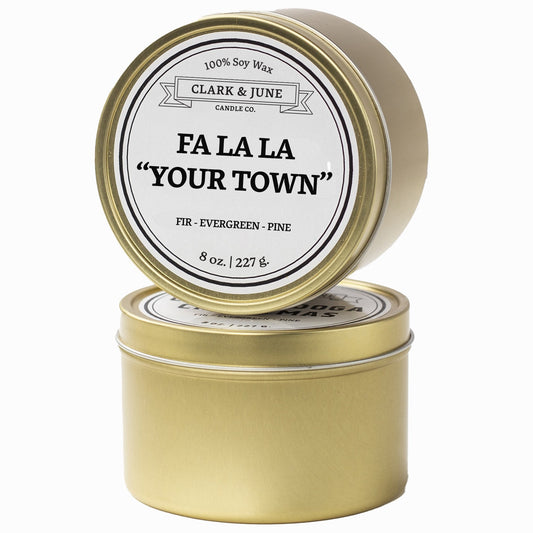 Single wicked Fir - Evergreen - Pine scented 8oz candle in gold finish with Fa La La "Your Town" on the label. SEO Text –soy wax candle, Christmas candle, Holiday candle hand poured, small batch, scented candle, Woman Owned, local candle, Housewarming present, gives back, charity, community candle, Soy wax candle Christmas gift.
