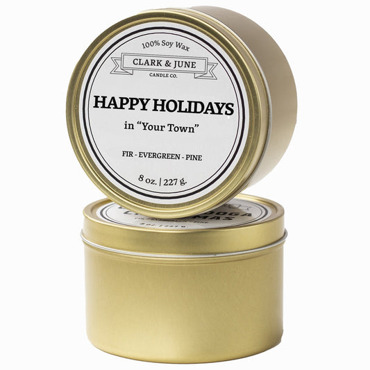 Single wicked Fir - Evergreen - Pine scented 8oz candle in gold finish with Happy Holidays in "Your Town" on the label. SEO Text –soy wax candle, Christmas candle, Holiday candle hand poured, small batch, scented candle, Woman Owned, local candle, Housewarming present, gives back, charity, community candle, Soy wax candle Christmas gift.
