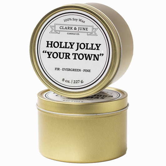 Single wicked Fir - Evergreen - Pine scented 8oz candle in gold finish with Holly Jolly "Your Town" on the label. SEO Text –soy wax candle, Christmas candle, Holiday candle hand poured, small batch, scented candle, Woman Owned, local candle, Housewarming present, gives back, charity, community candle, Soy wax candle Christmas gift.
