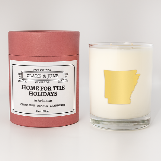 Double wicked soy candle in a 13.5 oz tumbler with the state of  Arkansas printed in 22k gold foil on the face. Red cylinder packaging with Home for the Holidays on the label. SEO Text â€“ Drinking glass, soy wax candle, Christmas Candle, hand poured, small batch, scented candle, Woman Owned, local candle, Housewarming present, gives back, charity, community candle, becomes a cocktail glass, closing gift. 
