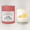 Load image into Gallery viewer, Double wicked soy candle in a 13.5 oz tumbler with the state of  Kentucky printed in 22k gold foil on the face. Red cylinder packaging with In my Santa Era on the label. SEO Text â€“ Drinking glass, soy wax candle, Christmas Candle, hand poured, small batch, scented candle, Woman Owned, local candle, Housewarming present, gives back, charity, community candle, becomes a cocktail glass, closing gift. 

