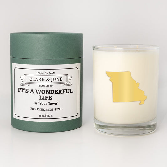 Double wicked soy candle in a 13.5 oz tumbler with the state of Missouriprinted in 22k gold foil on the face. Green cylinder packaging with It's a Wonderful Life in "Your Town"on the label. SEO Text – Drinking glass, soy wax candle, Christmas Candle, hand poured, small batch, scented candle, Woman Owned, local candle, Housewarming present, gives back, charity, community candle, becomes a cocktail glass, closing gift. 