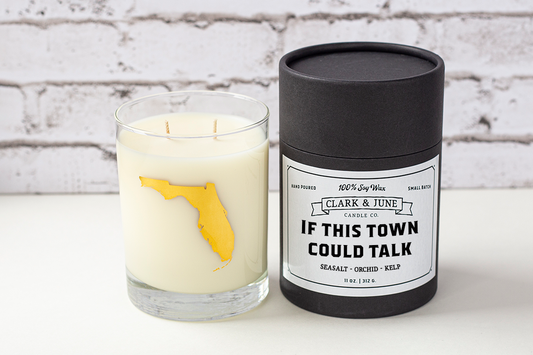 Double wicked soy candle in a 13.5 oz tumbler with the state of Florida printed in 22k gold foil on the face. Black cylinder packaging with “If This Town Could Talk” on the label. SEO Text – Drinking glass, soy wax candle, Florida candle, hand poured, small batch, scented candle, Woman Owned, local candle, Housewarming present, gives back, charity, community candle, becomes a cocktail glass, closing gift. 