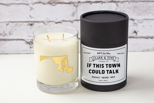 Double wicked soy candle in a 13.5 oz tumbler with the state of Maryland printed in 22k gold foil on the face. Black cylinder packaging with “If This Town Could Talk” on the label. SEO Text – Drinking glass, soy wax candle, Maryland candle, hand poured, small batch, scented candle, Woman Owned, local candle, Housewarming present, gives back, charity, community candle, becomes a cocktail glass, closing gift.