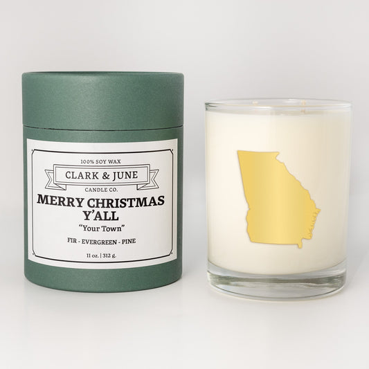 Double wicked soy candle in a 13.5 oz tumbler with the state of Georgiaprinted in 22k gold foil on the face. Green cylinder packaging with Merry Christmas Y'All "Your Town"on the label. SEO Text – Drinking glass, soy wax candle, Christmas Candle, hand poured, small batch, scented candle, Woman Owned, local candle, Housewarming present, gives back, charity, community candle, becomes a cocktail glass, closing gift. 