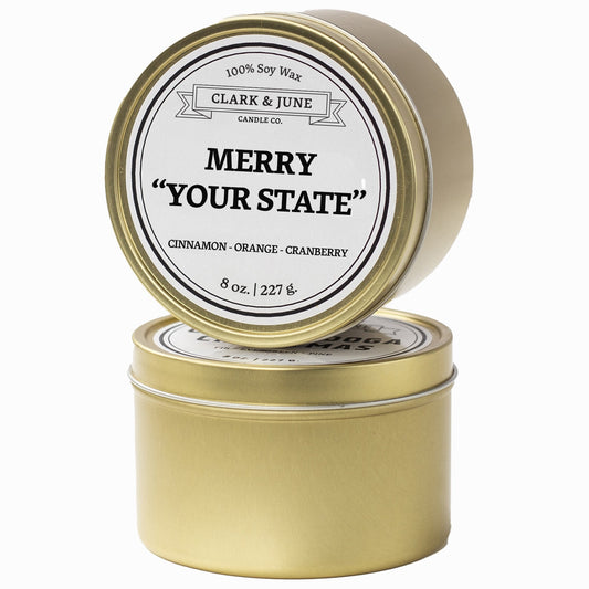 Single wicked Cinnamon - Orange - Cranberry  scented 8oz candle in gold finish with Merry "Your State" on the label. SEO Text –soy wax candle, Christmas candle, Holiday candle hand poured, small batch, scented candle, Woman Owned, local candle, Housewarming present, gives back, charity, community candle, Soy wax candle Christmas gift.
